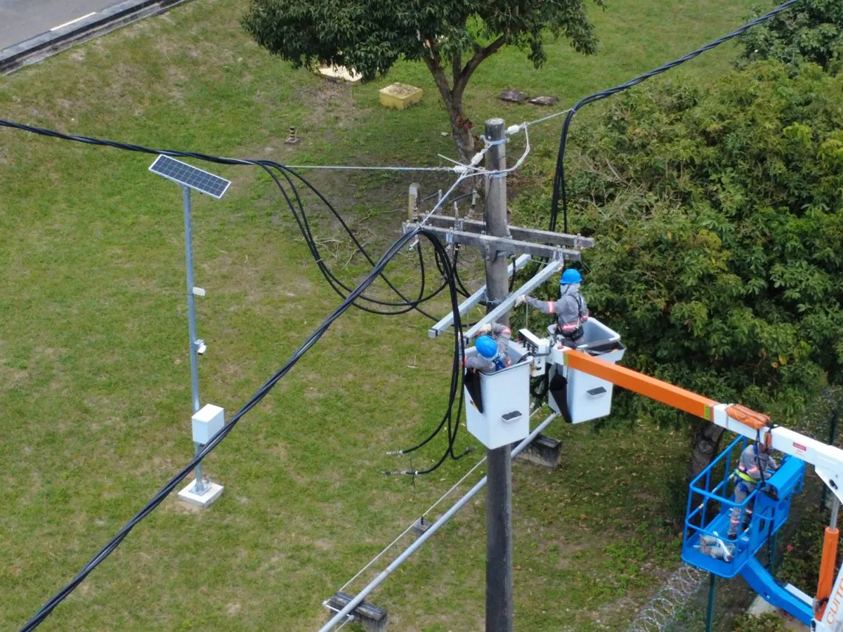 Eletricistas no cesto aéreo trabalhando na rede de média tensão do Terminal Temadre, em Madre de Deus, vista de cima